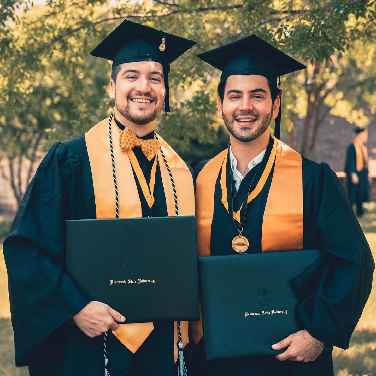 Two Sigma Nu brothers celebrating their Kennesaw State University graduations